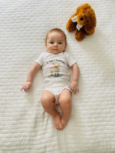Baby wearing white onesie with words I am Chosen and a baby lamb imagine
