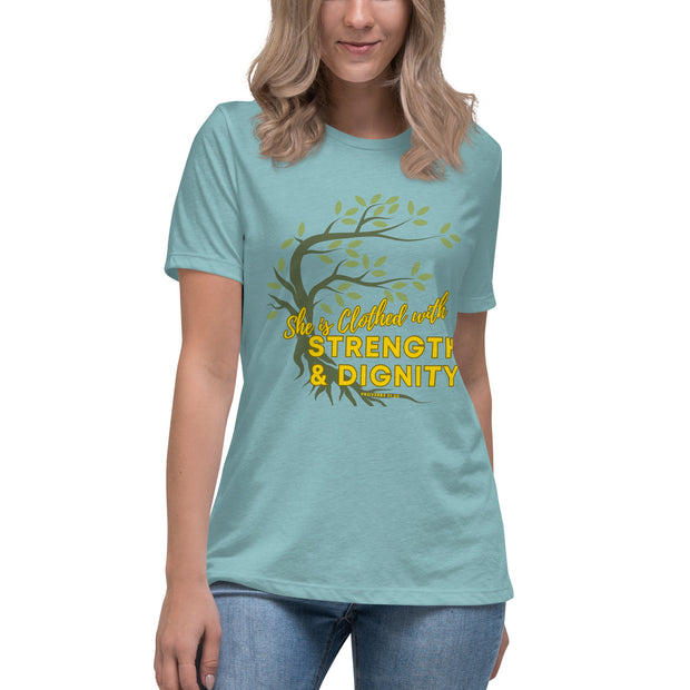 Young women wearing pastel blue t-shirt with image of tree branched over the scripture "She is clothed with strength and dignity" Proverbs 31:25. Tree is dark olive with green leaves. Lettering is yellow.