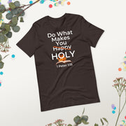 Brown Christian T-shirt with white bold lettering that reads "Do what make you happy holy, 1 Peter 1:15".  The word happy is crossed out and there's a holy flame and a bible image behind the holy.